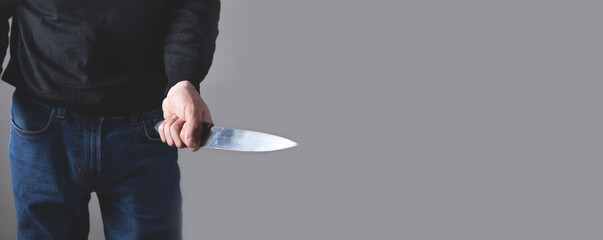 Caucasian aggressive man threatening with fist and holding knife.