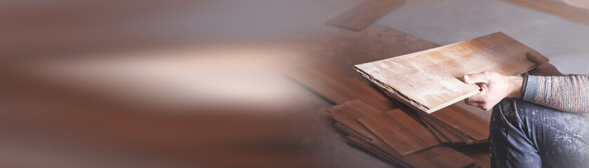 Worker installing new laminate wooden floor.