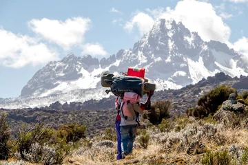 Photo sur Plexiglas Kilimandjaro Mount Kilimanjaro with native porters carrying pack on their heads