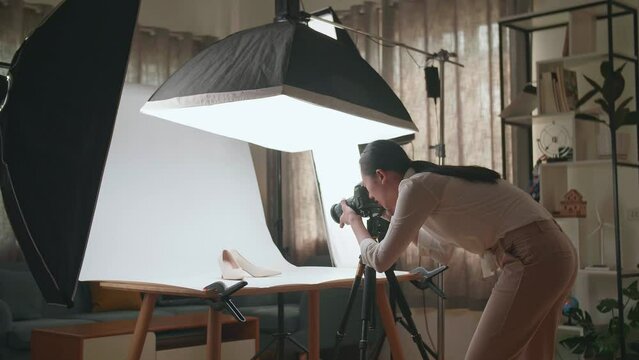 Asian Female Photographer Taking Photos Of Women'S Shoes In Home Studio 
