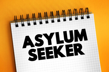 Asylum seeker -person who leaves their country of residence, enters another country and applies for asylum in this other country, text concept on notepad