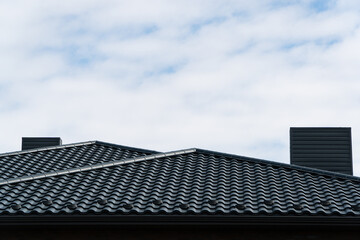 Fototapeta na wymiar The roof is made of black metal tiles