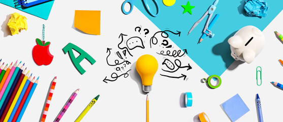 Brainstorming concept with a light bulb and school supplies - Flat lay