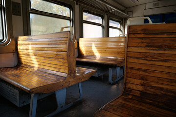Fototapeta na wymiar Old empty wagon of train. Wooden seats in an empty coach of train