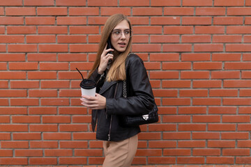 young woman journalist walking around the city with coffee