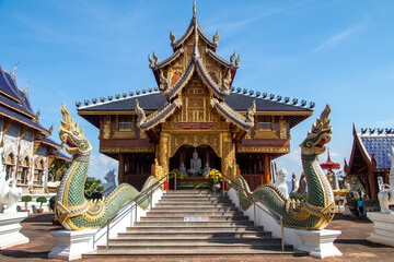 Thai Buddhist temple with blue tiled roof and white statues