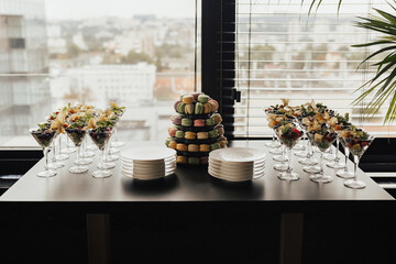 A black table with a buffet of fruits and desserts at the event.