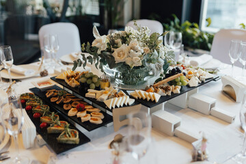 Wedding table decoration and aperitifs on it. Buffet table with food and snacks for the guests of the event. 