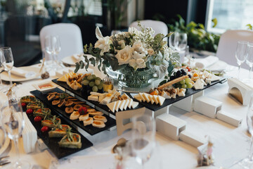 Wedding table decoration and aperitifs on it. Buffet table with food and snacks for the guests of...