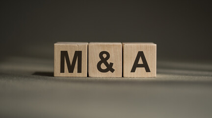 Obraz premium Wooden cube with the letter M and A. gray background. business conceptual word collected of of wooden elements with the letters.