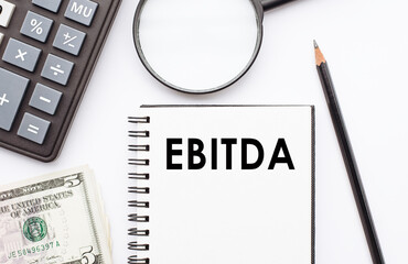 Paper notepad with word EBITDA on an office table