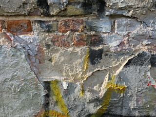 Fragment of an old brick wall with peeling plaster creating abstract patterns, Lodz, Poland.