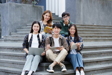 Fototapeta premium Young Asian woman college student with friends at outdoors. College student working on the college campus, education, school, study