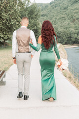 Young teenage couple dressed up for the prom, walking together. Back view