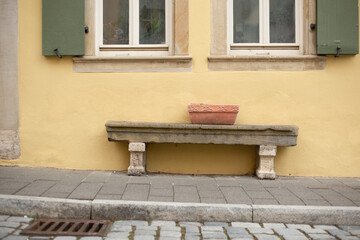 Fototapeta na wymiar Sitzbank unter zwei Fester, auf dem Gehweg, Rothenburg ob der Tauber