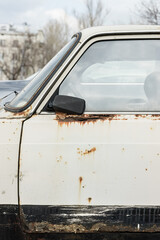 Old rusty and dusty car parked in the street..