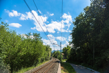 The iron rails are covered with rubble. Bright landscape with a railway