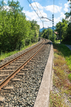 The iron rails are covered with rubble. Bright landscape with a railway