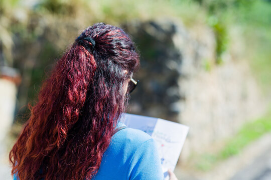 Unrecognizable mid latin woman searching on a map during travel tourist vacation. Lifestyle portrait