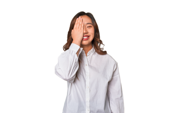 A young chinese woman having fun covering half of face with palm.