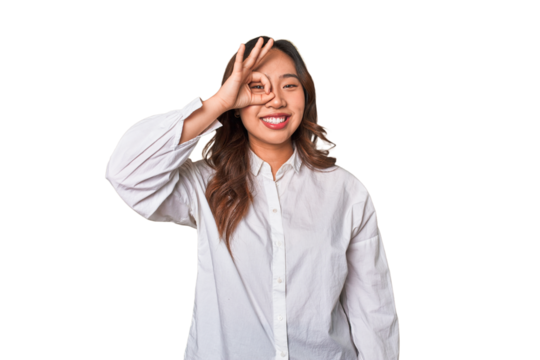 A young chinese woman excited keeping ok gesture on eye.