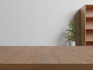 A wooden table with a plant in the background