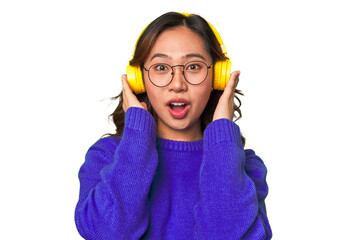 Joyful Asian woman wearing headphones, enjoying music and having fun