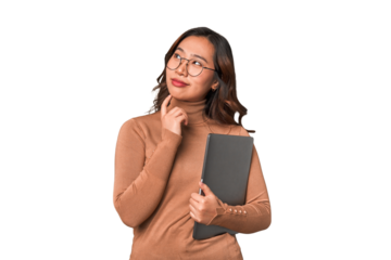 young asian woman holding a laptop thinking on some new ideas