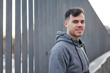 Young caucasian man exudes coolness, leaning in the street.