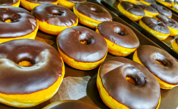 Chocolate and sugar donuts in supermarket bakery shelf in Mexico.