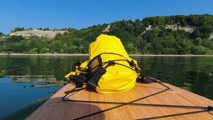 POV view of paddle board with sport equipment, outdoor activities, yellow waterproof bag, oar...