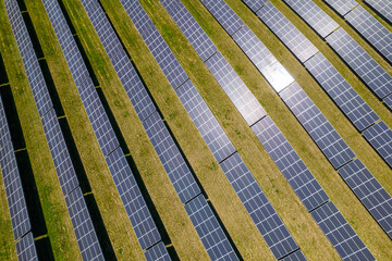 View of modern photovoltaic solar panels to charge battery. Rows of sustainable energy solar panels set up on the farmland. Green energy and environment ecology concept.