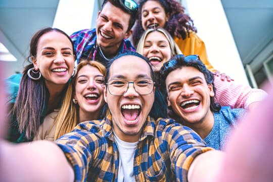 Happy group of multiracial friends taking selfie shot outside on holiday- Young people taking photo looking at camera and having fun- Youth diversity and community concept with guys 