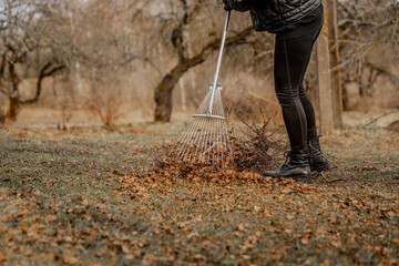 Woman raking garden in autumn