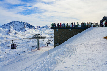 Tourists enjoying the view over the French Alps from a boardwalk platform at the top of La Masse...