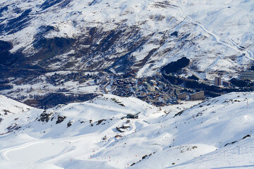 Fototapeta na wymiar Town of Les Ménuires in a snowy valley of the French Alps, as seen from the summit of La Masse mountain in winter