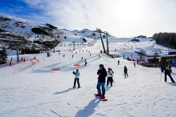 Les Ménuires, France - March 16, 2023 : Skiers going down the ski slopes in Les Ménuires ski resort in the French Alps in winter © Alexandre ROSA