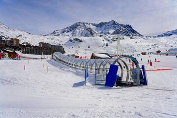 Tapis roulant dans un tunnel de verre sur la piste de ski d'une école de ski de Val Thorens dans...