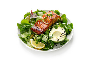 Healthy green salad with avocado and baked roasted salmon steak. Fresh diet dinner meal. Vitamin food concept on the plate isolated on white background with clipping path.