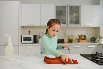 Girl wiping kitchen counter with soft cloth
