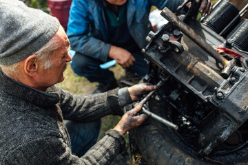 Plakat tractor car engine repair at home, old man repairs the engine.