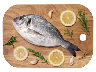 Raw whole dorado fish on wooden kitchen board and spices for cooking, top view