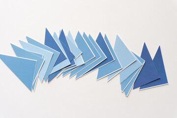 set of layered blue triangles on blank paper