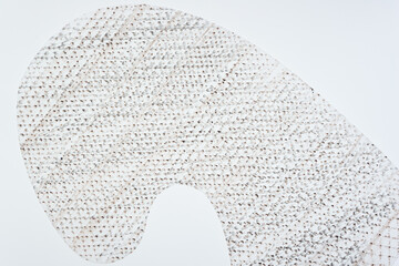 frottage technique featuring a grid or net pattern on tracing paper and photographed on a white backlit surface