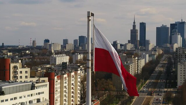 Flaga Polski powiewająca na tle centrum Warszawy