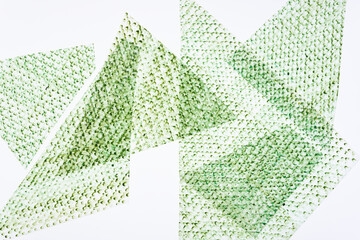 frottage technique featuring a grid or net pattern on tracing paper and photographed on a white backlit surface