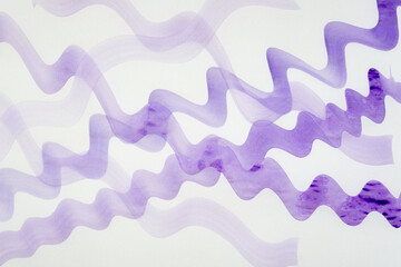 tracing paper with overlapping wet purple watercolor paint markings on a backlit surface