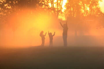 Family playing in the early morning fog