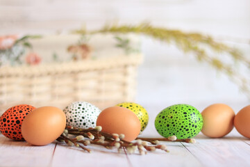 Easter eggs close-up on a wooden table and willow twigs. Painted Easter eggs are a traditional symbol of a religious holiday. Christian traditions of celebration