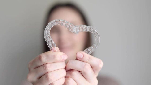 A young girl uses aligners to straighten her teeth